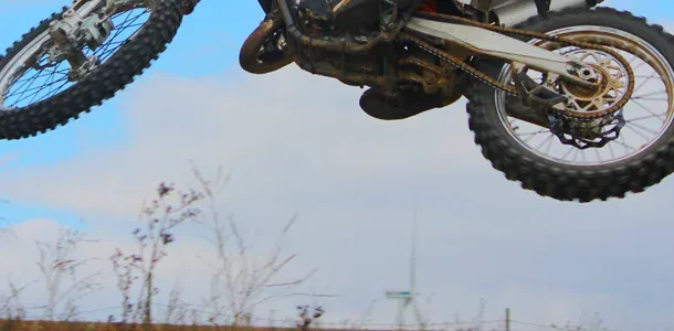 Nahaufnahme: Motocross-Maschine in der Luft über einem Sprung